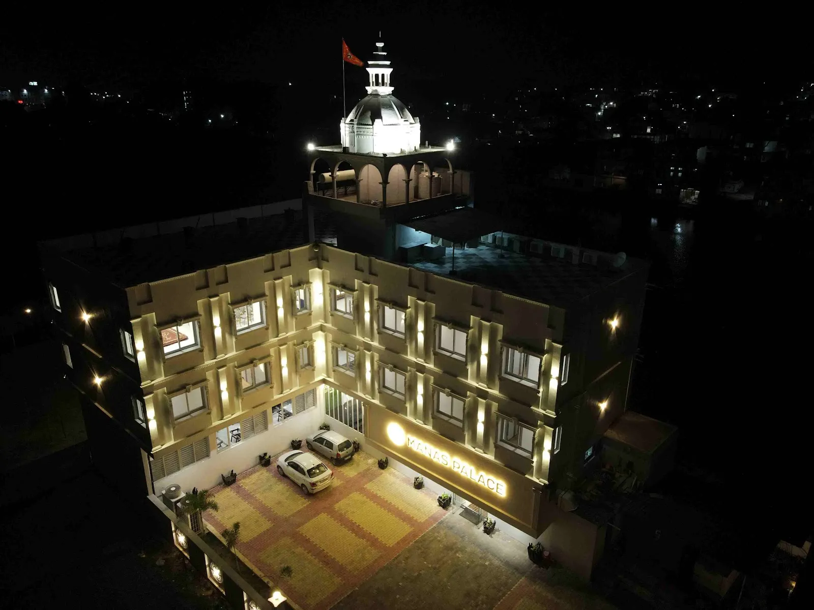 रात में रोशनी से जगमगाता होटल मानस पैलेस, ऊपर से