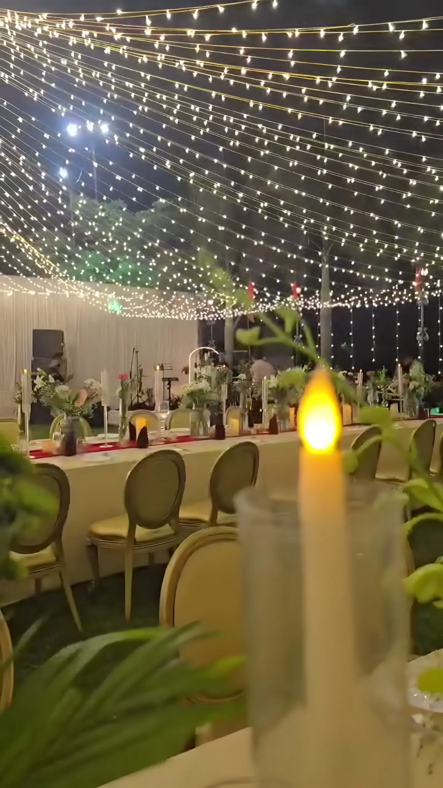 A candle on a dinner table under the lights