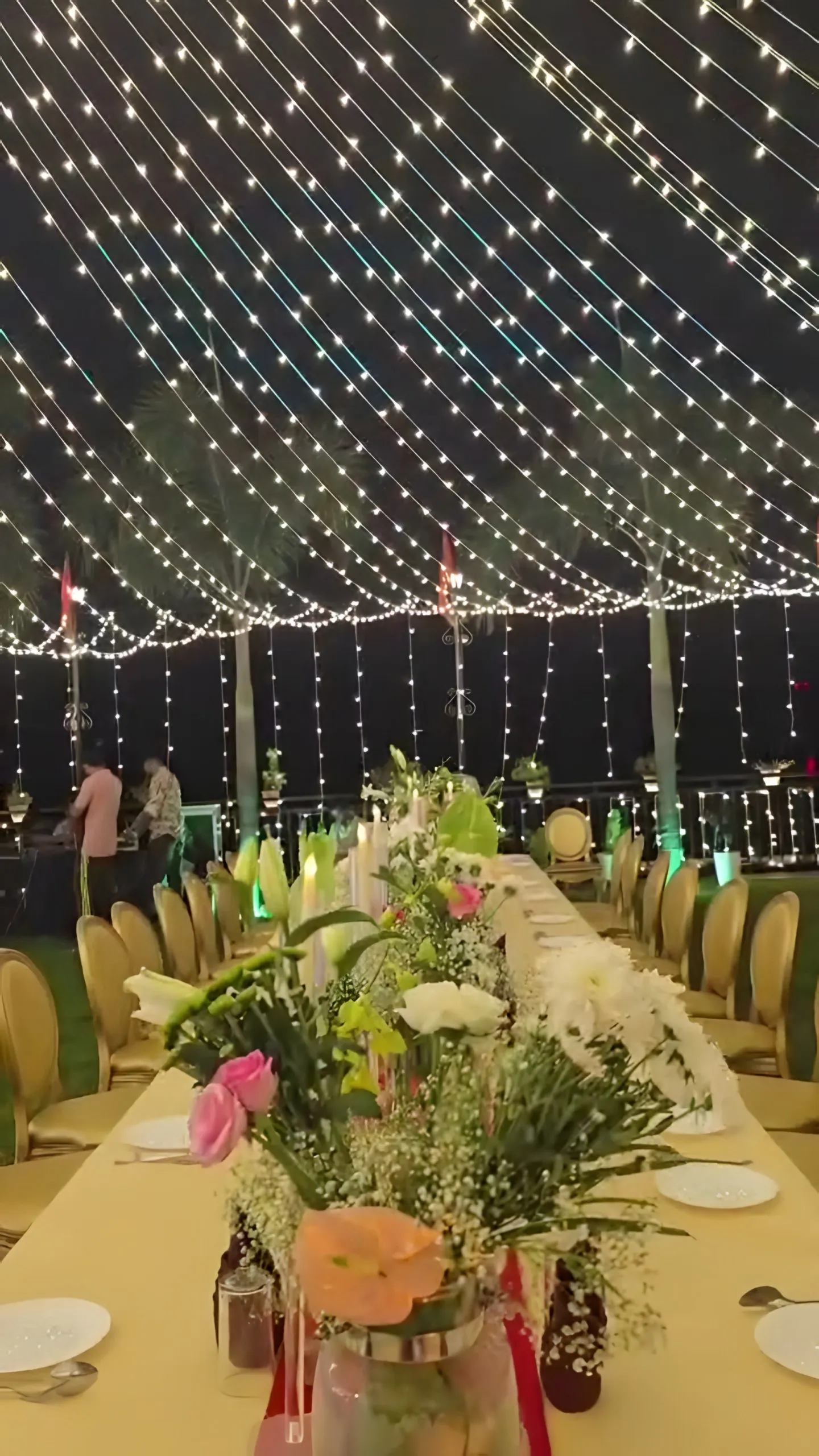 Dinner tables with flowers and candles under the lights