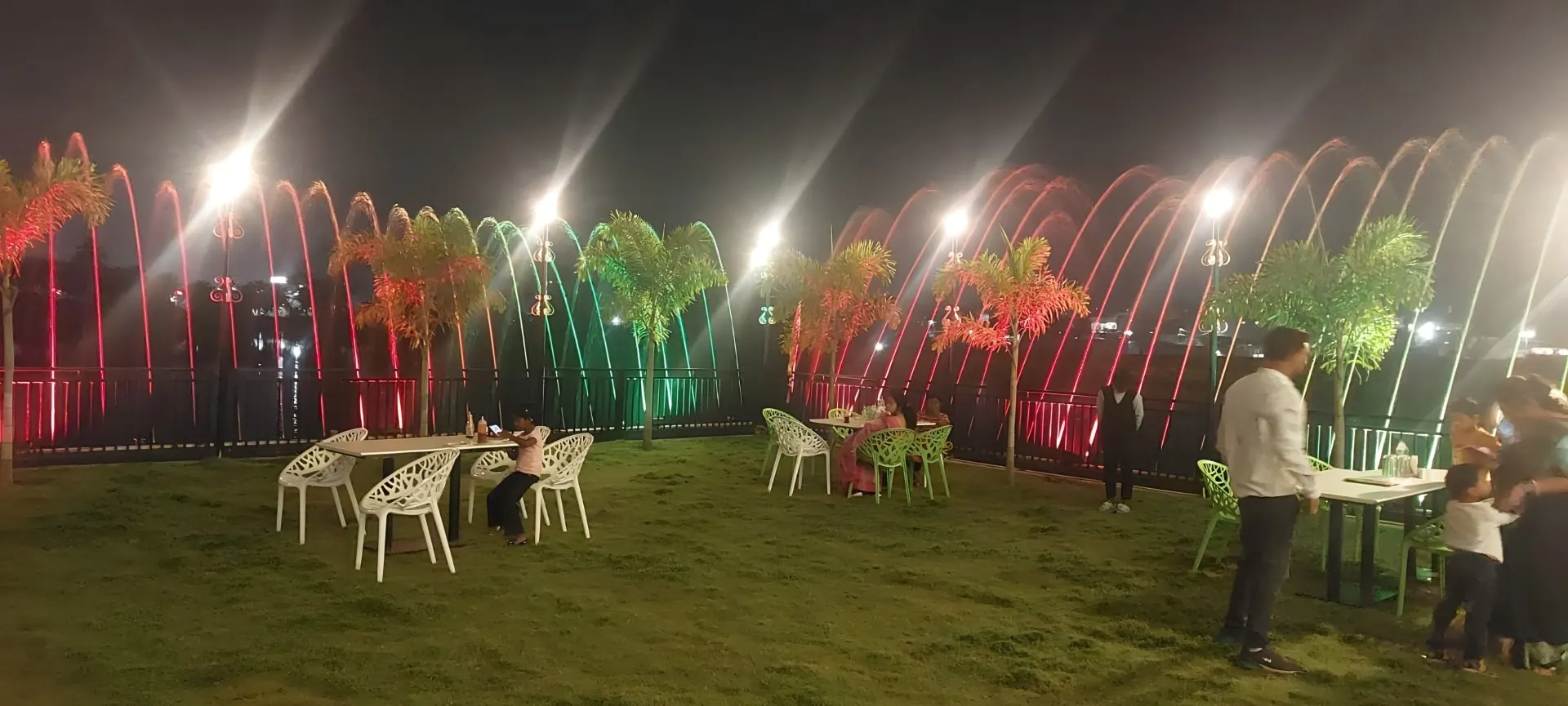 The lawn lit with coloured lights at night